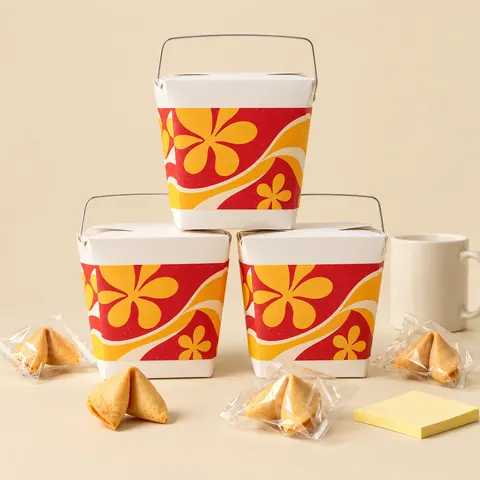 Concept art of “Office Omiyage”: three stacked takeout pails with a floral print, a mug, a sticky note and wrapped fortune cookies. The real pails are plain white.